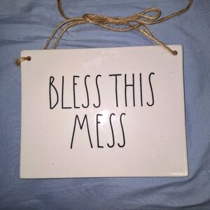 A Rae Dunn Bless This Mess wall plaque with sisal string hanger.